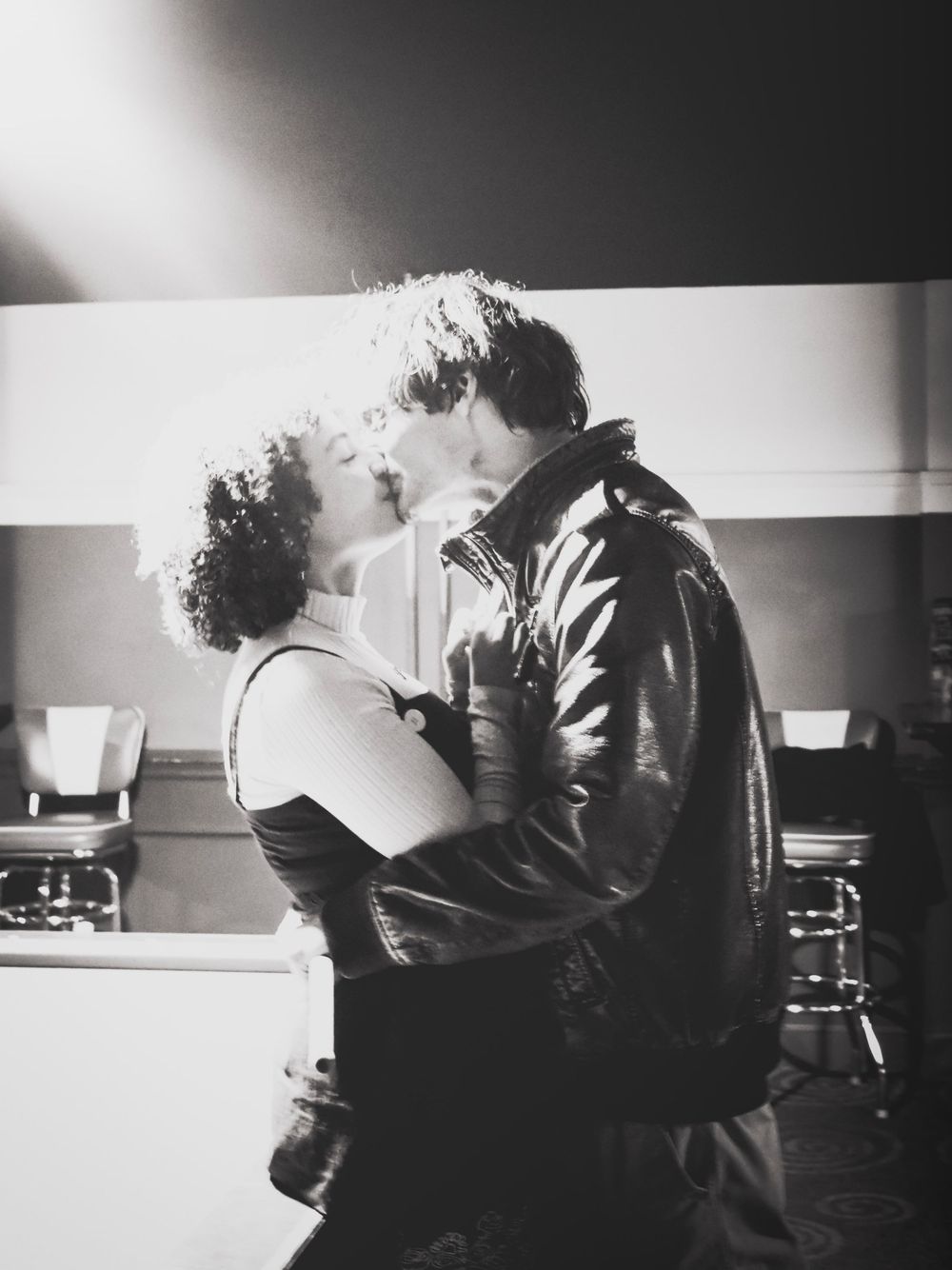 Black and white romantic moment captured in intimate lighting.