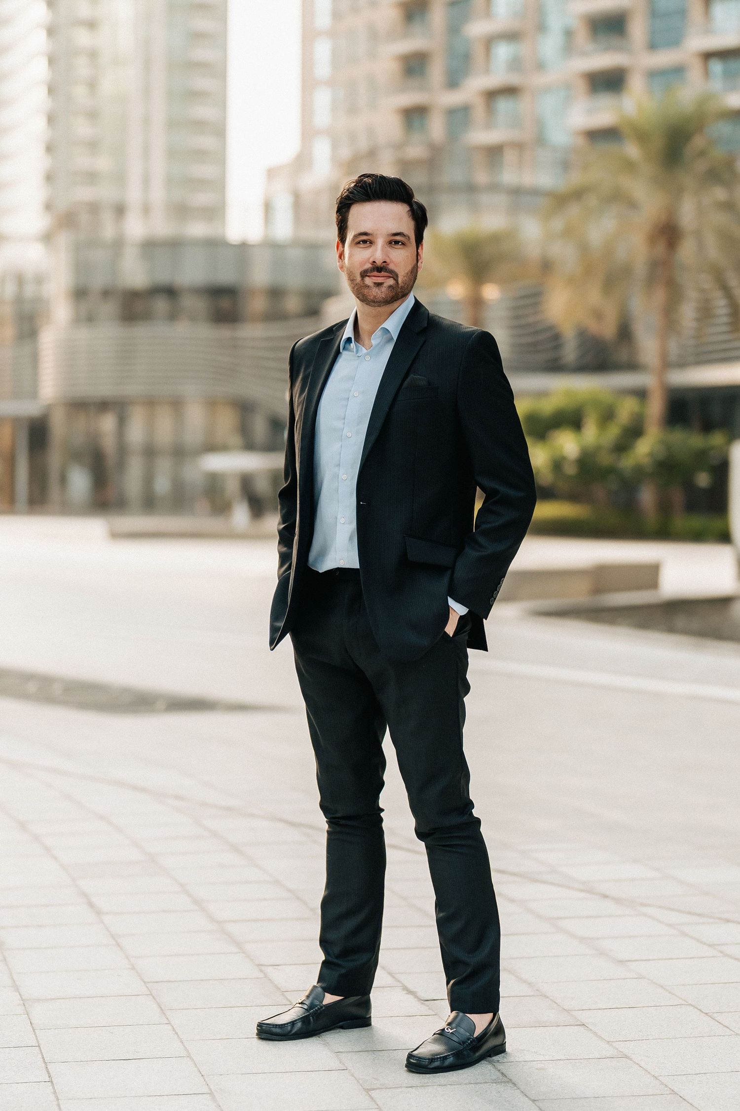 Urban lifestyle portrait of man standing near modern building