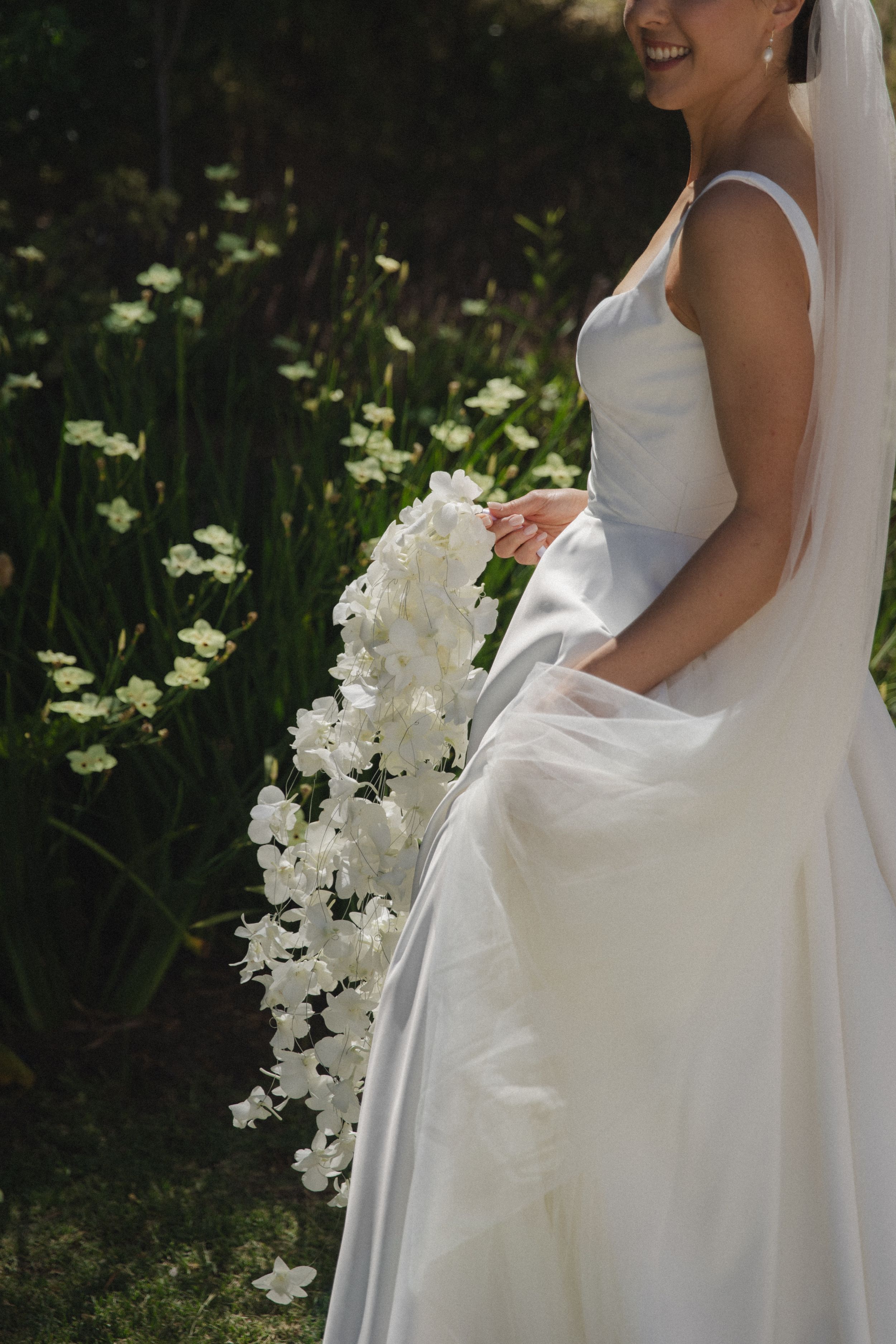 Close-up of the cascading orchid bouquet with textured white florals.