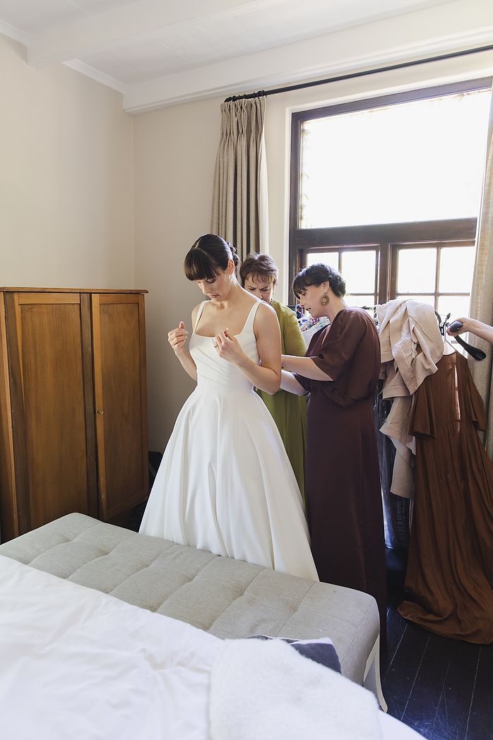 Bride and family assisting with her dress