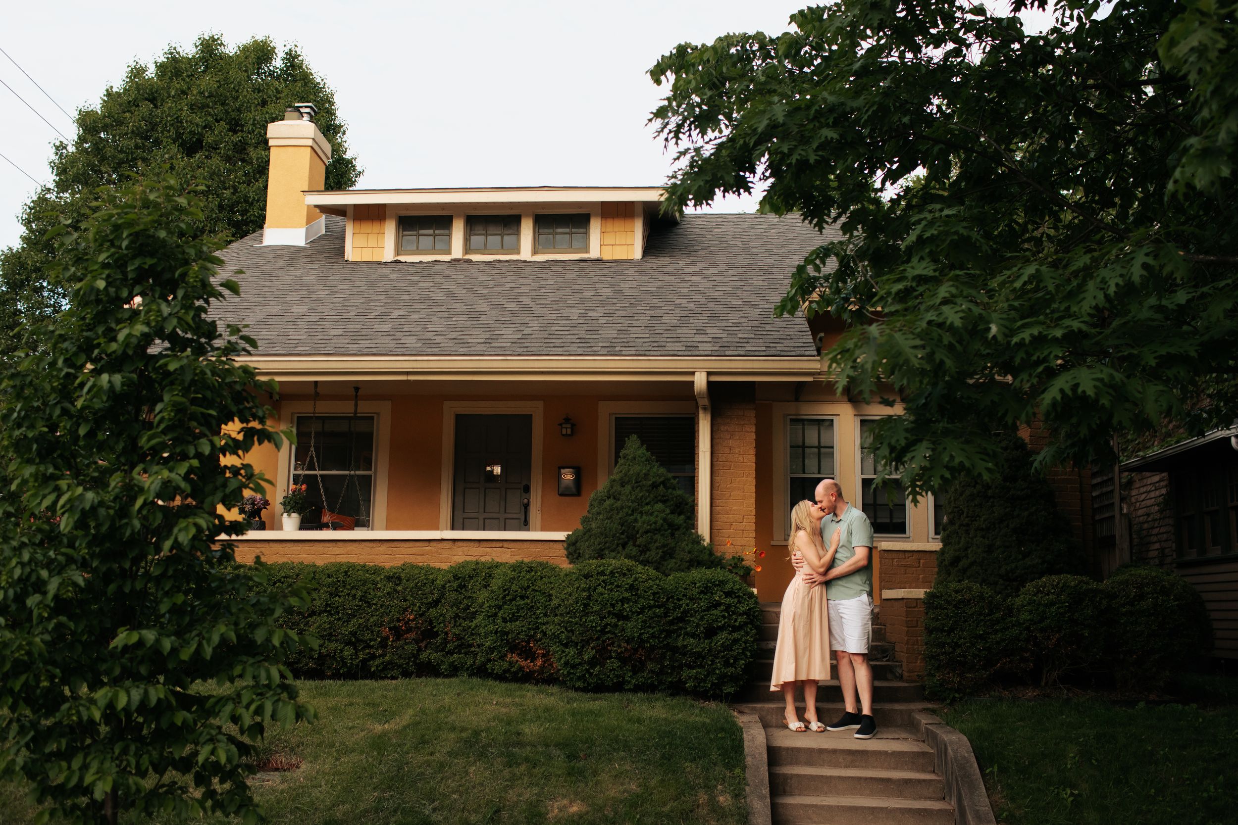 A series of connected images showing a couple walking and standing outside a mid-century modern house at dusk.