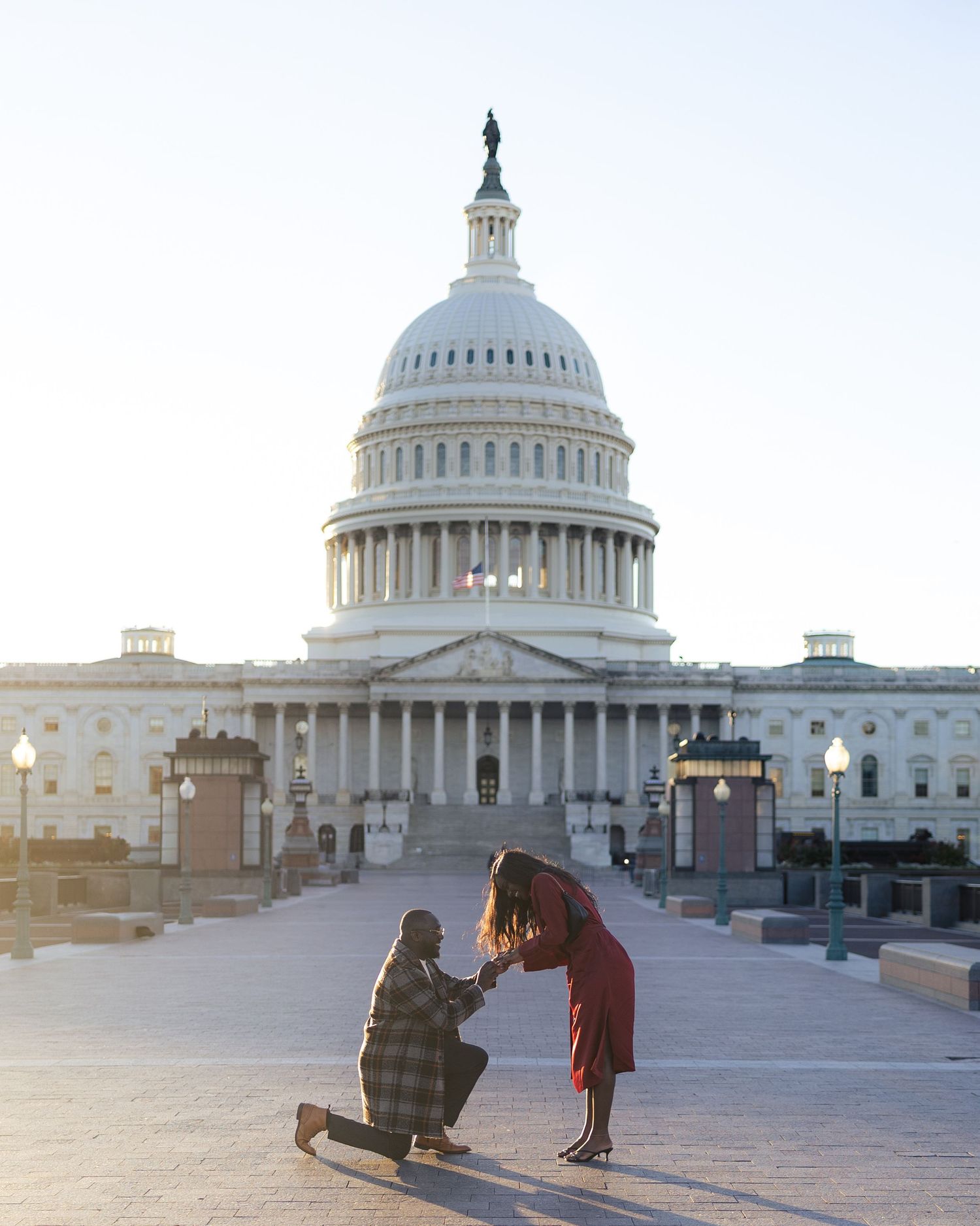 A romantic proposal moment unfolds on a tree-lined dirt path as a couple shares a special moment together.