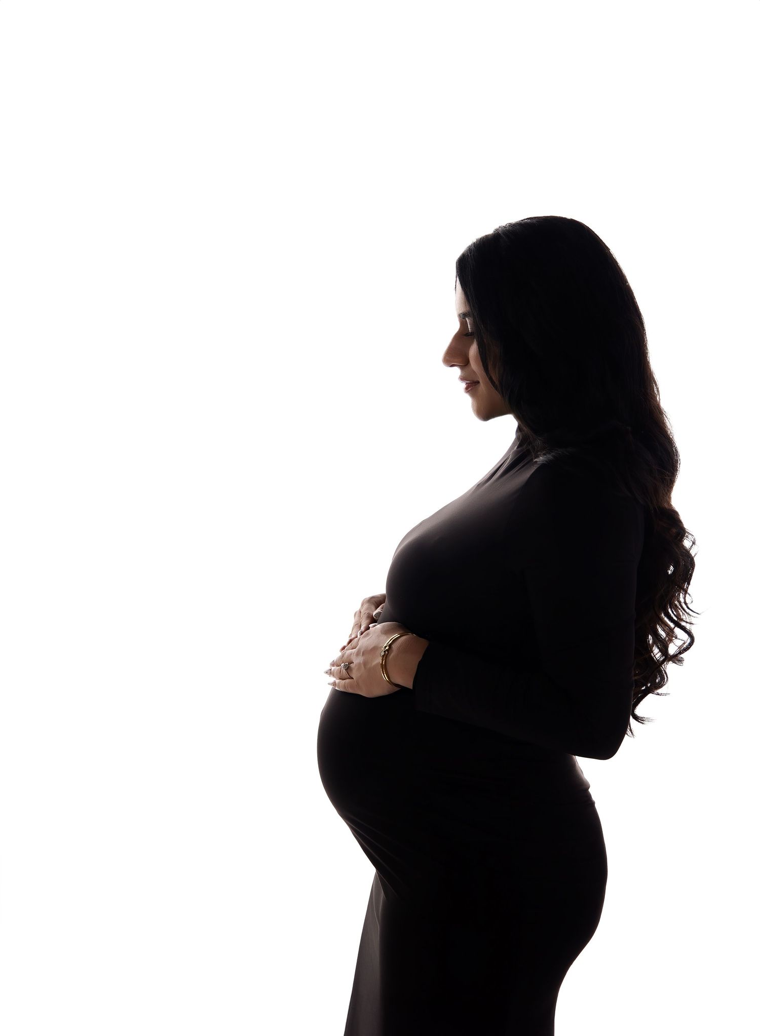 Modern back lit maternity portrait by Austin Maternity Photographer featuring profile pose wearing black bodycon dress.