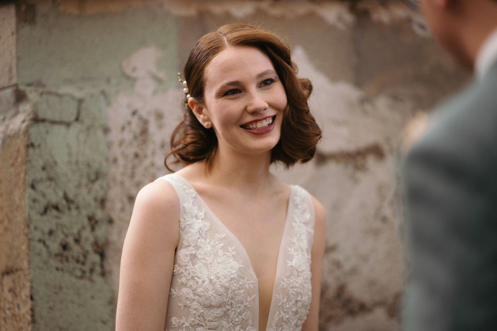 Wedding celebration in an elegant outdoor garden setting with stone walls.