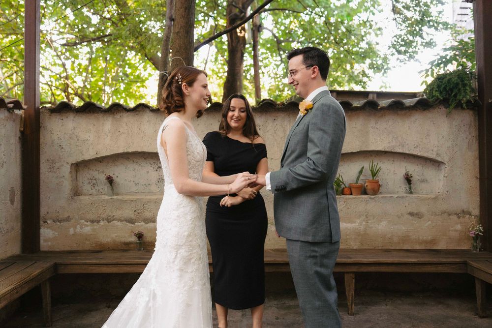 Couple in formal attire standing together at an outdoor venue.