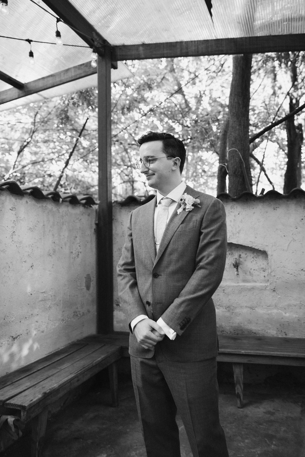 Black and white photo of formal event preparations in a covered outdoor space.