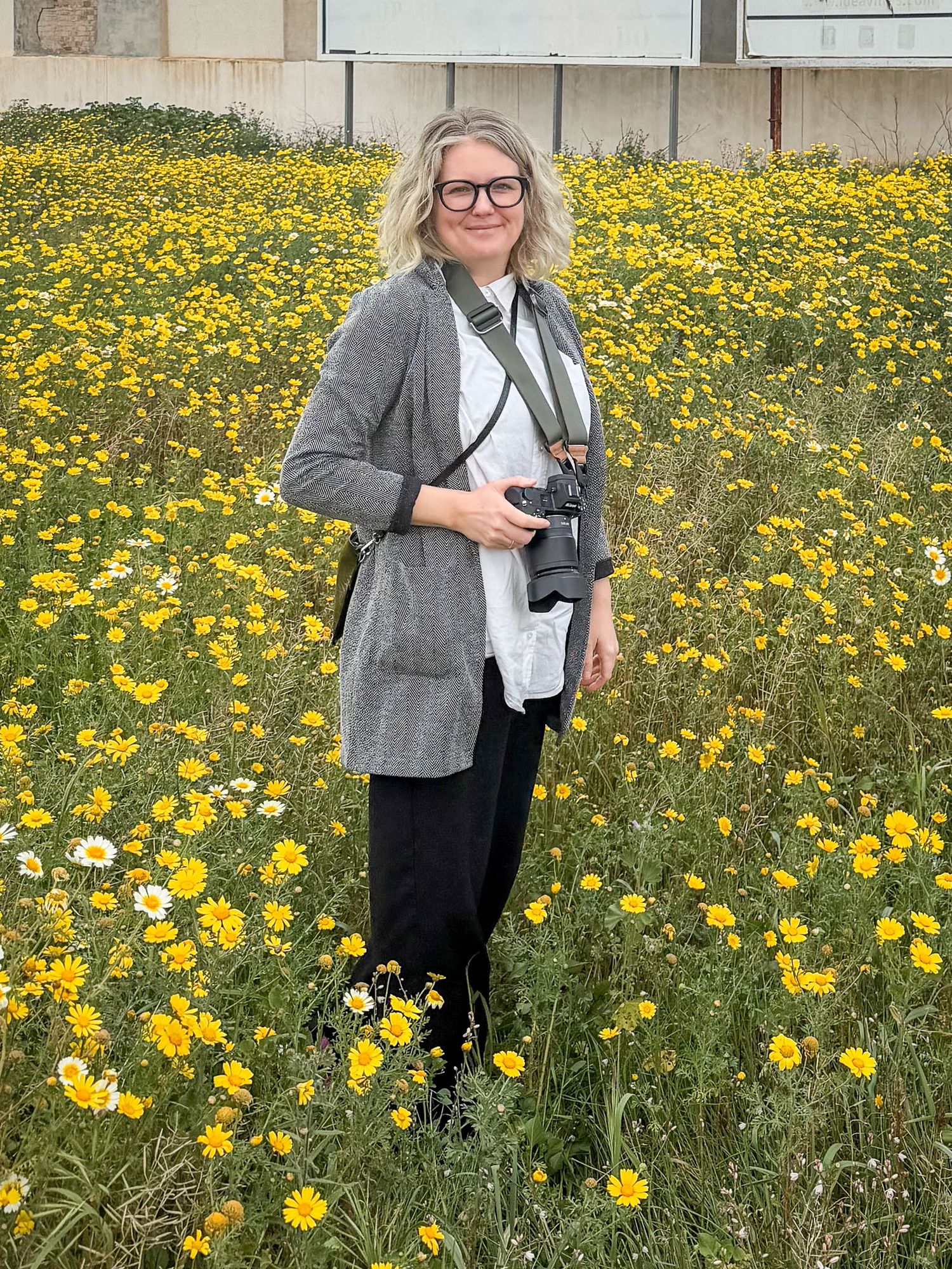 Fotograf Jessica Lindqvist stående på ett gult fält i Spanien.