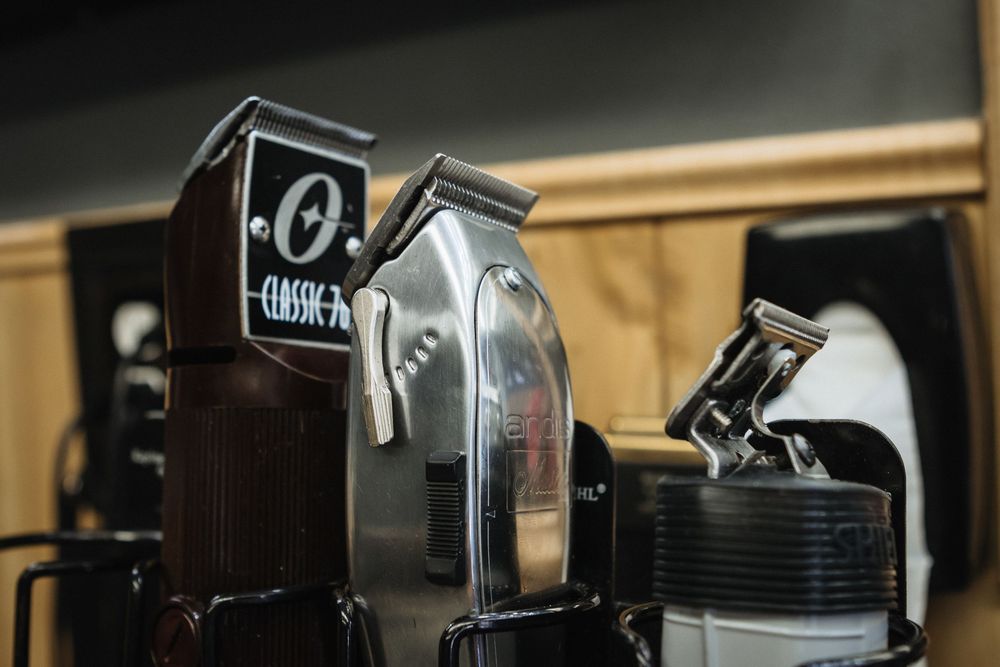 Close-up of professional barber equipment and clippers in a modern barbershop setting.