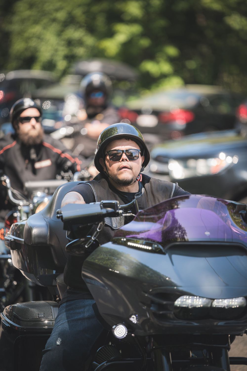 Motorcyclists gathered on their bikes at an outdoor event.
