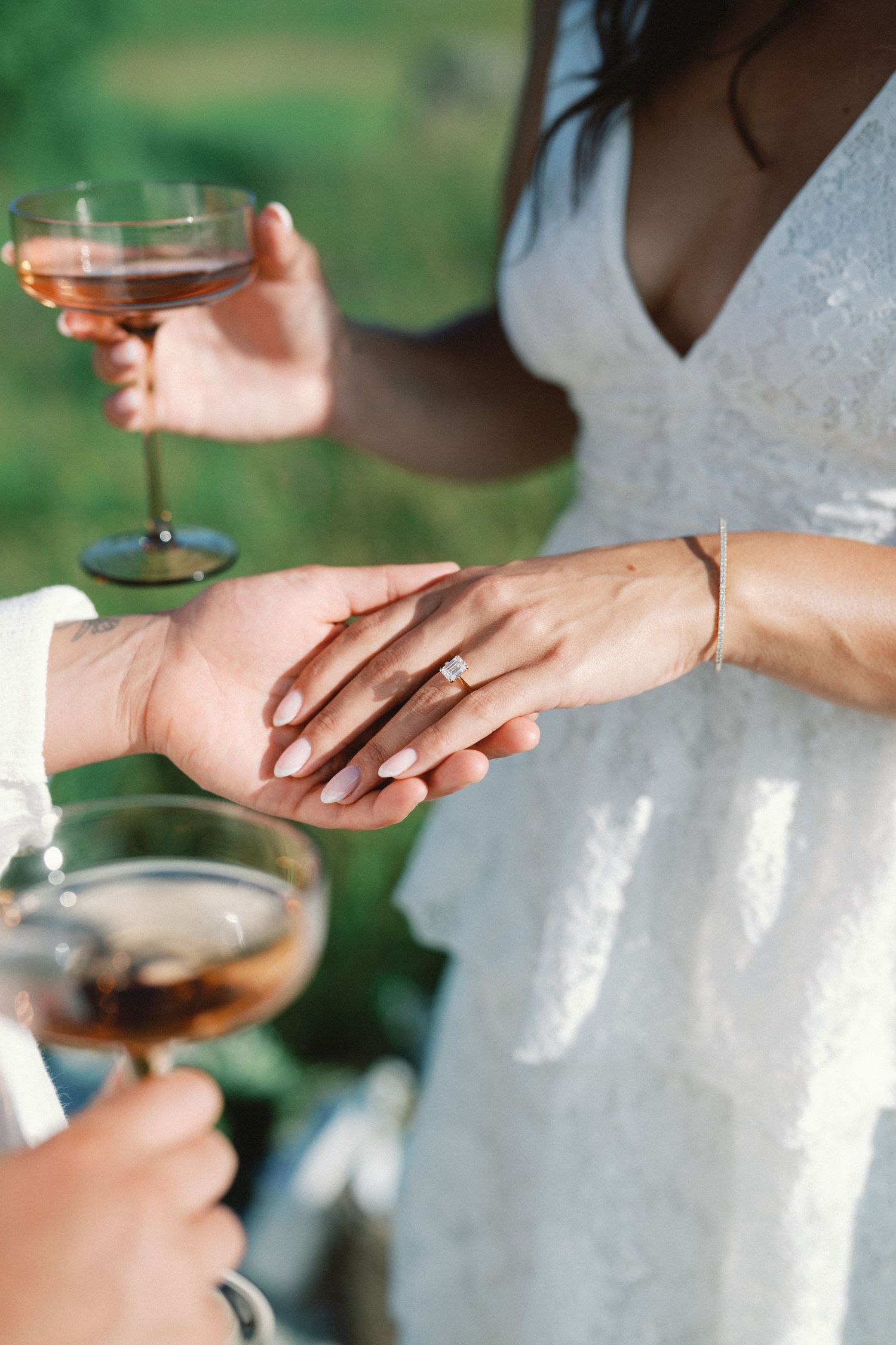 Close-up view of hands exchanging wedding rings during an outdoor ceremony with soft natural lighting.