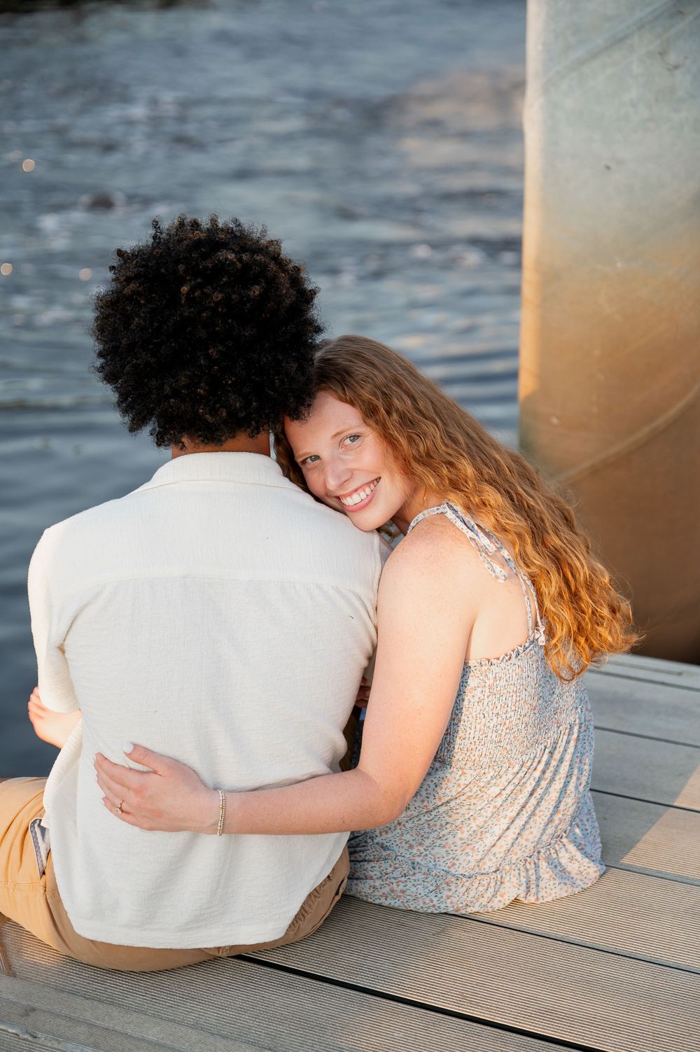A couple sits together on a wooden dock at sunset, sharing intimate moments in a series of candid photos.