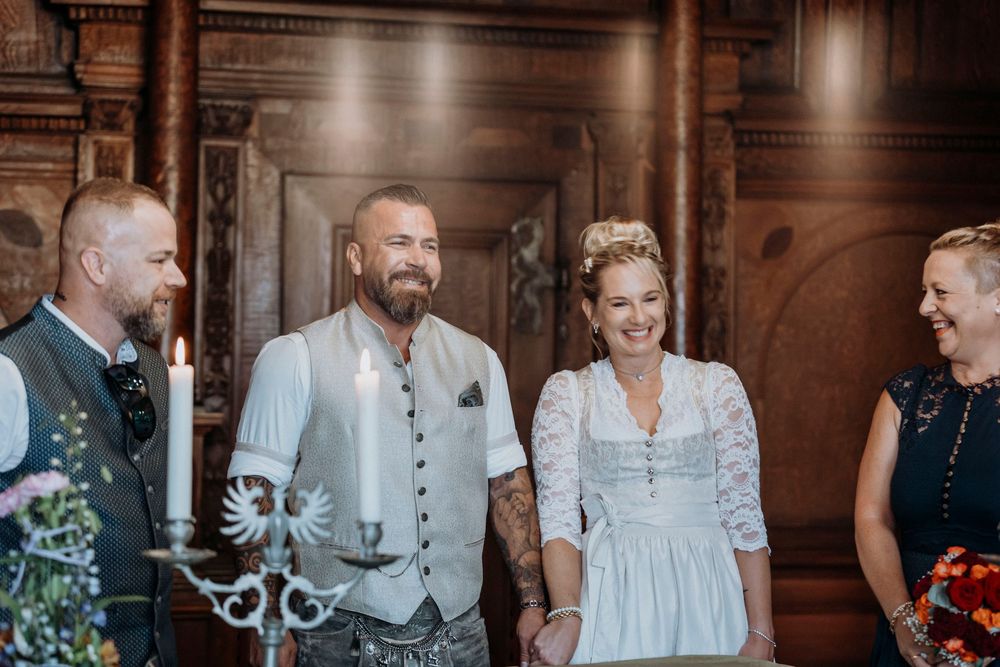 Wedding party members sharing joyful moments in a rustic wooden interior.