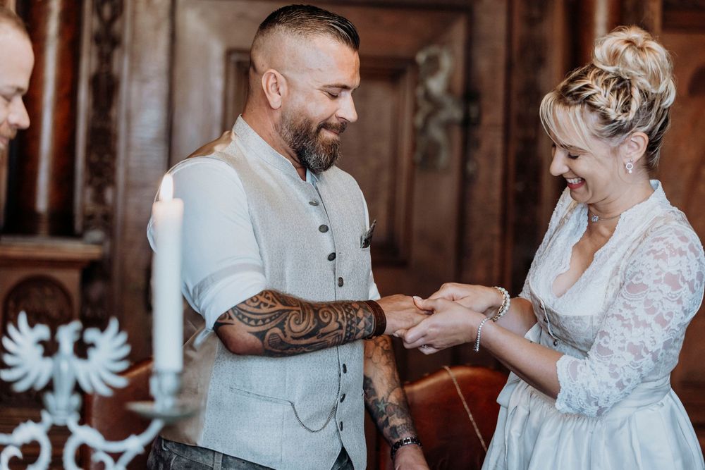 Traditional wedding ring exchange ceremony in an elegant wood-paneled room.