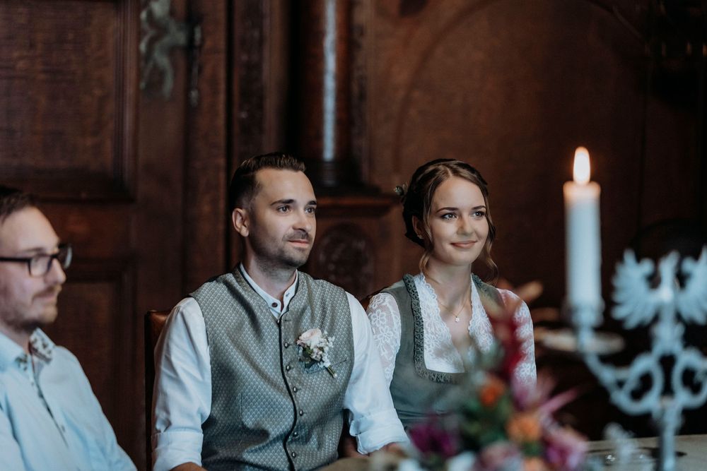 Wedding ceremony scene with candlelight in a traditional wooden interior.