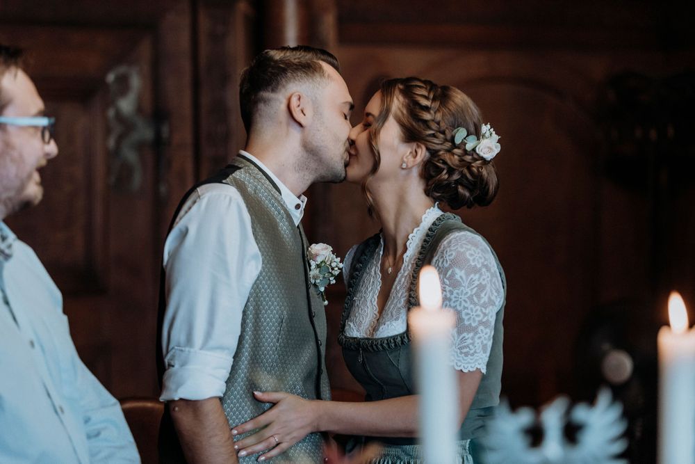 Intimate wedding moment captured in moody lighting with candles.