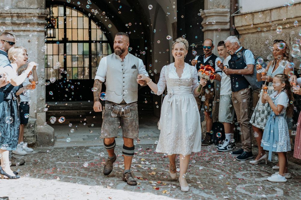 Celebratory exit with guests throwing confetti outside a historic building.