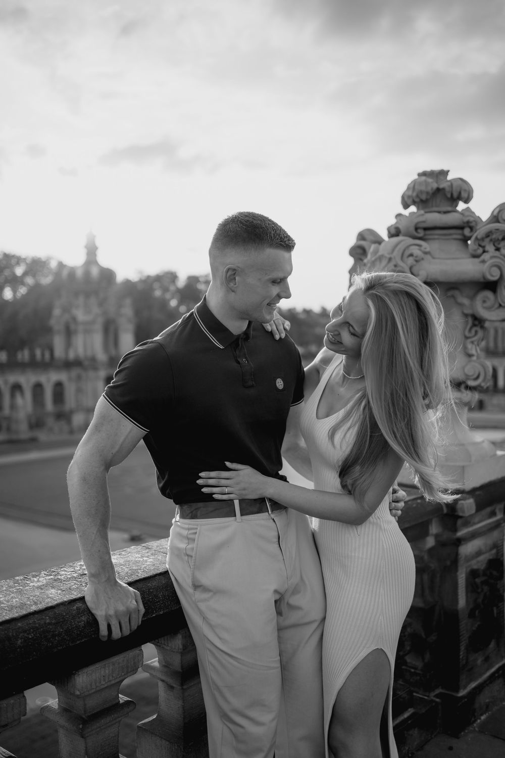 A romantic black and white photo series showing a couple embracing on a city bridge.