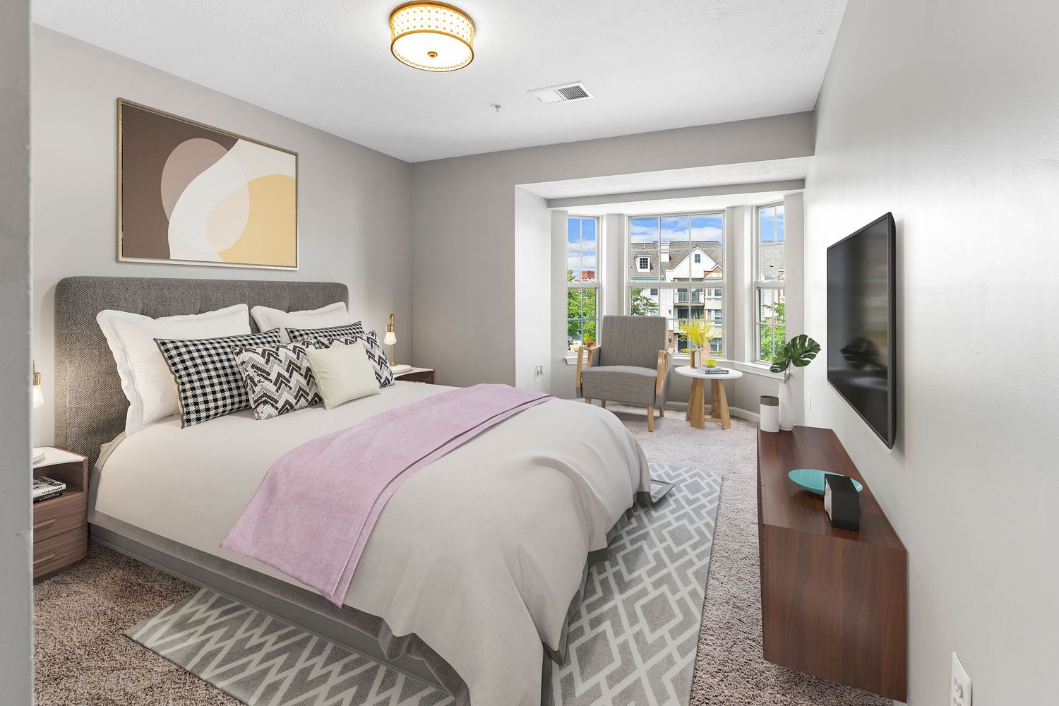 Cozy bedroom with grey carpet, modern lighting fixture, and natural light from windows.