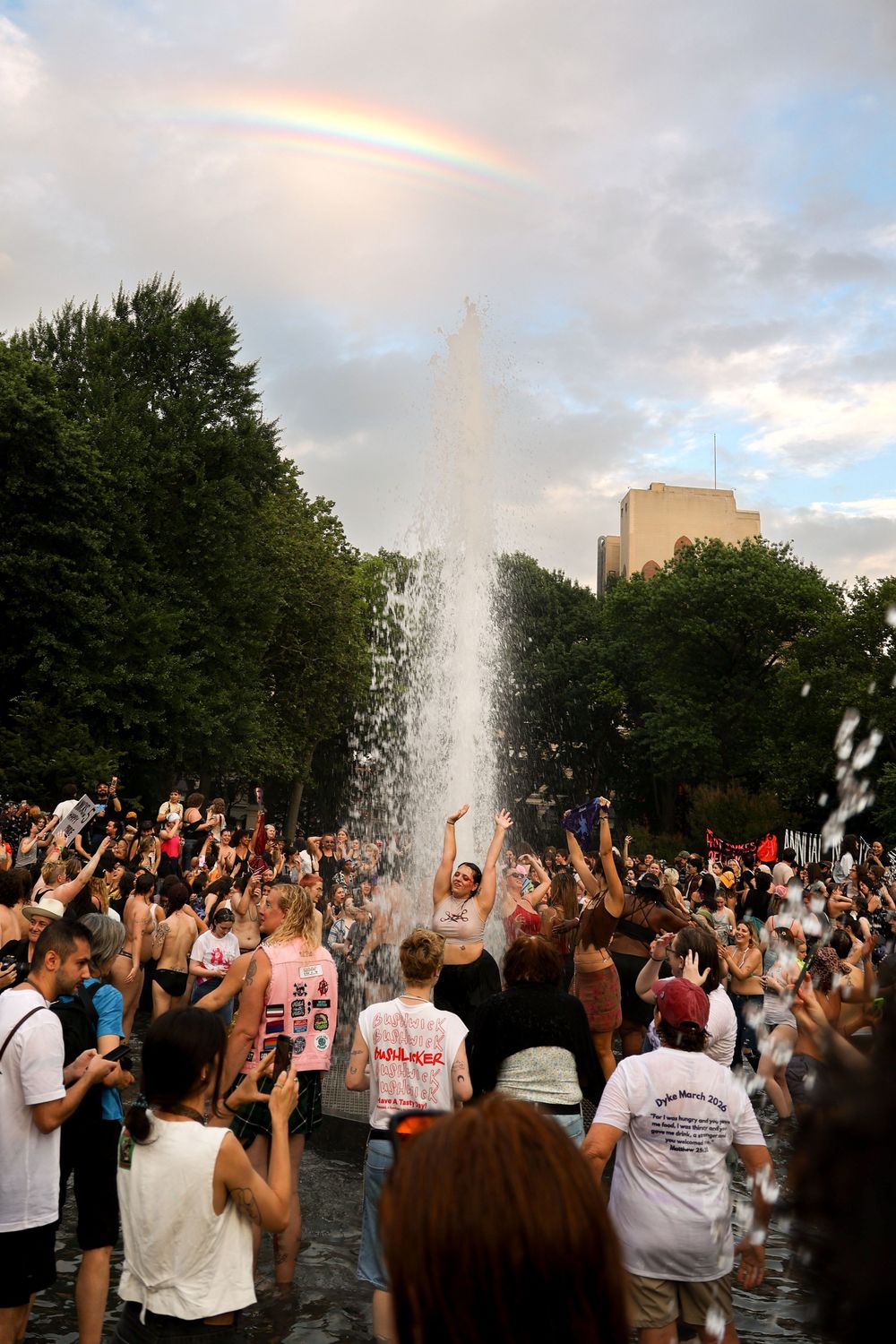 Rainbow over 2026 Annual New York City Dyke March attendees in Washington Square Park fountain in Manhattan, New York City.