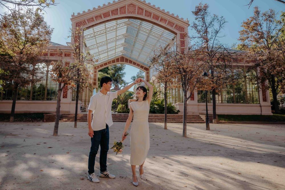 Wide shot of couple framed by historic architecture in Barcelona.