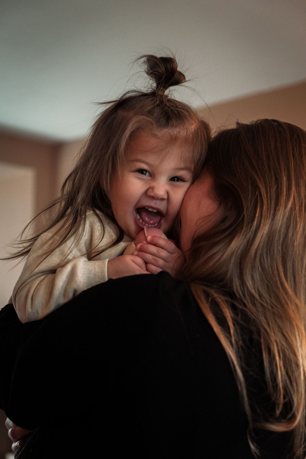 A heartwarming sequence of candid moments showing affectionate embraces and joyful laughter between parent and child.