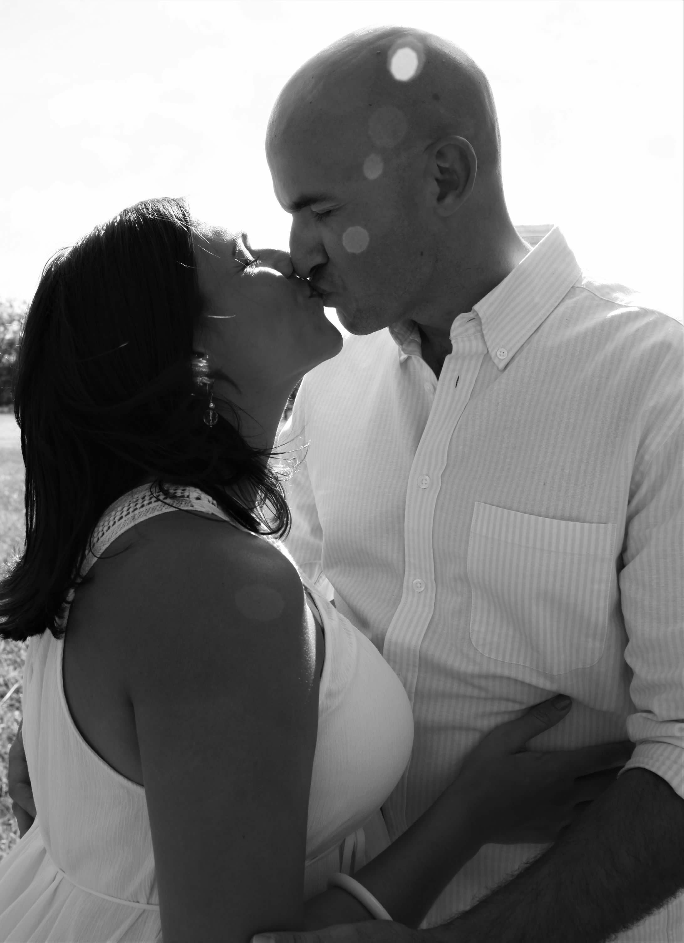 An intimate black and white portrait of a romantic couple sharing a tender moment.
