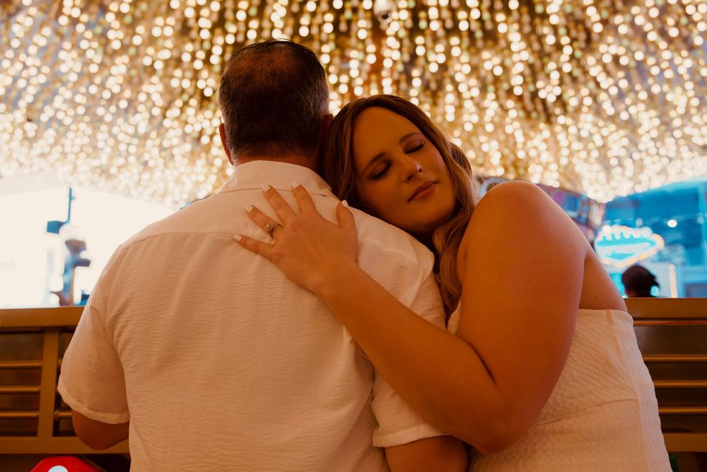 Couple sharing a tender embrace under a canopy of sparkling fairy lights in Las Vegas.
