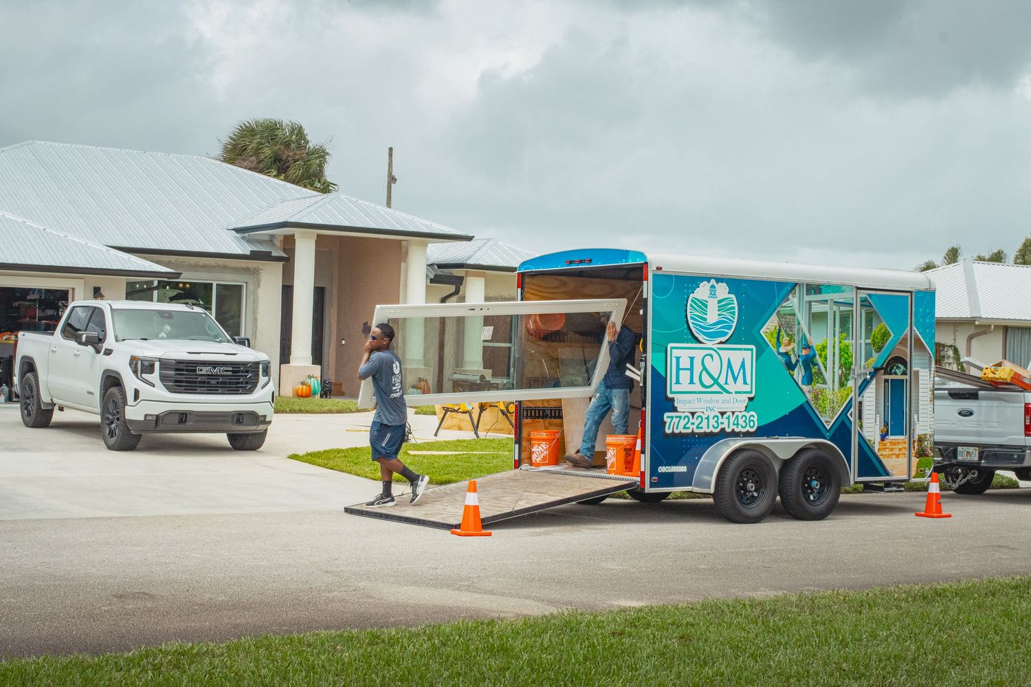 Brand photography of trailer and men carrying impact window for H&M Impact Window and Door in Fort Pierce, FL.