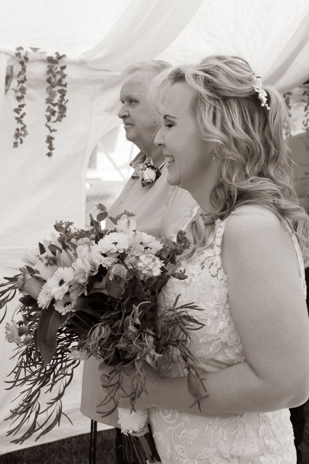 Two brides holding bouquets of flowers at a wedding ceremony in black and white photo.