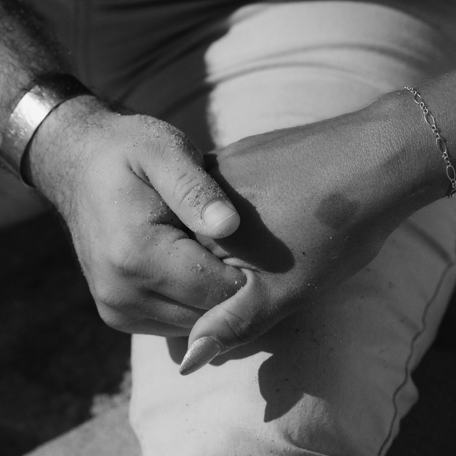 Couple holding hands at Pompano Beach Pier during engagement couples session.
