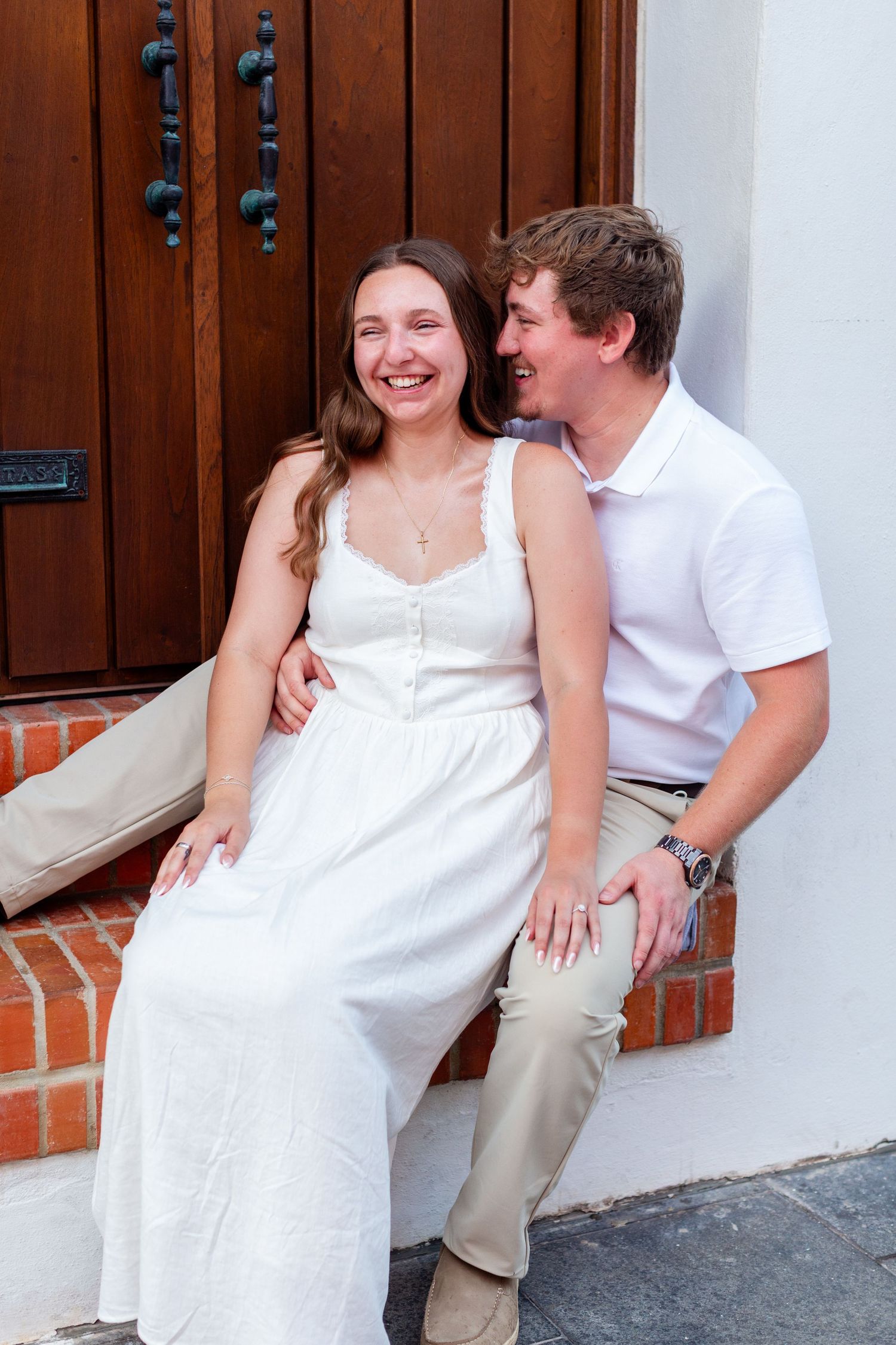 Couples portrait seated in a doorway. Engagement photo session in Old San Juan, Puerto Rico.