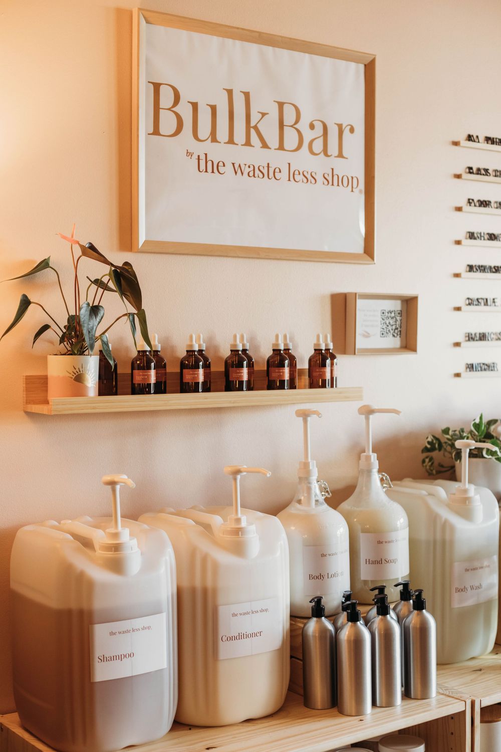 Bulk refill dispensers and amber bottles displayed at an eco-friendly BulkBar zero waste shop with minimalist decor.