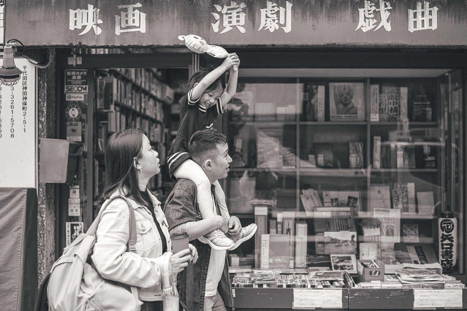 Mum and dad with child exploring Tokyo's book district Jimbocho for a family portrait session
