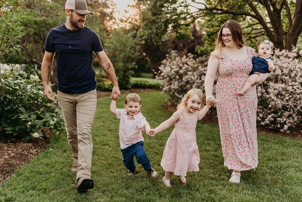 Family walking together through a blooming spring garden path.