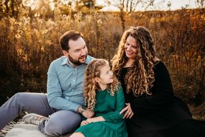 A couple shares tender moments during a golden hour photoshoot in a rustic outdoor setting.