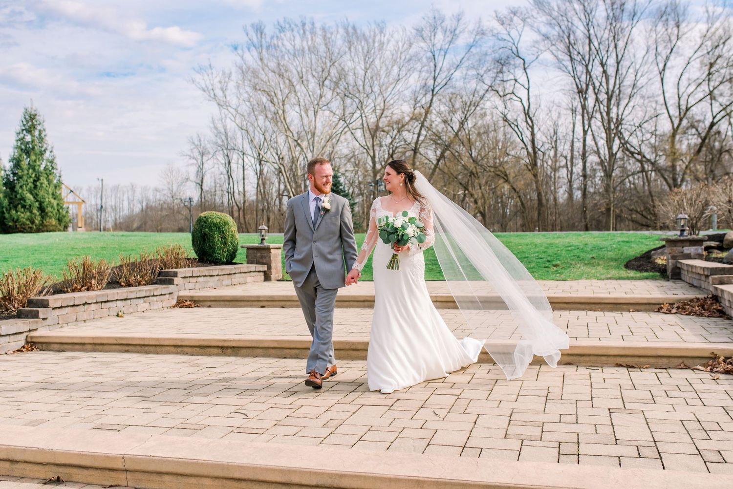 Scenic lakeside wedding portrait with evergreen trees in the background.