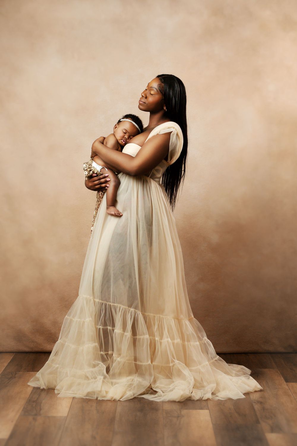 Ethereal cream tulle maternity gown captured in studio portrait session.