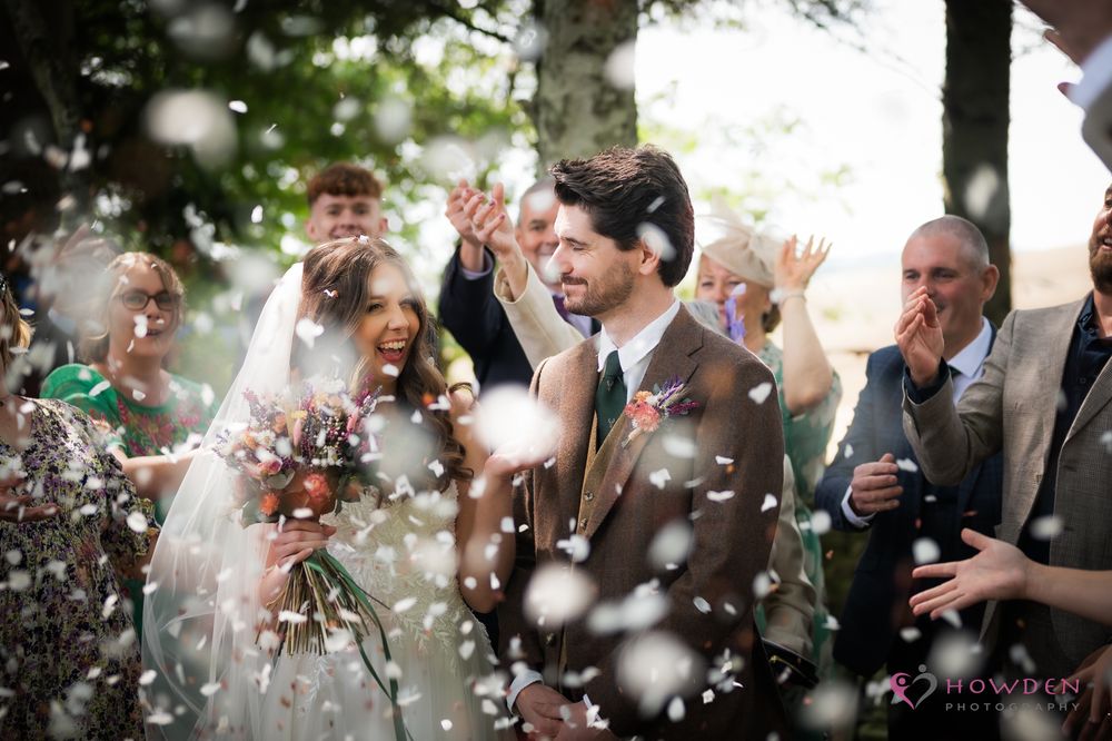 Bubbles float through the air as happy wedding guests laugh and celebrate together during an outdoor celebration.