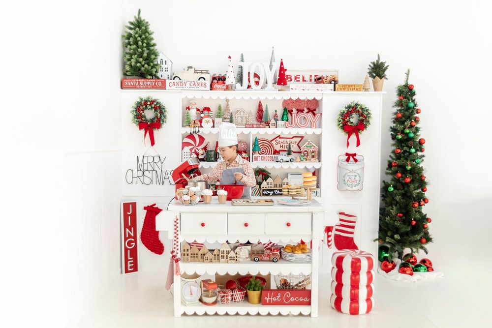 A young boy poses on a Christmas baking studio set.