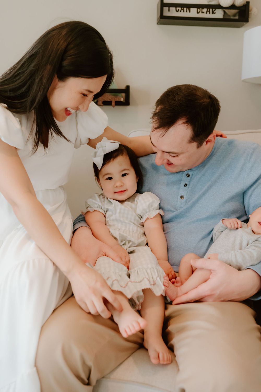 A family sits together on a couch sharing a tender moment in their bright home interior.