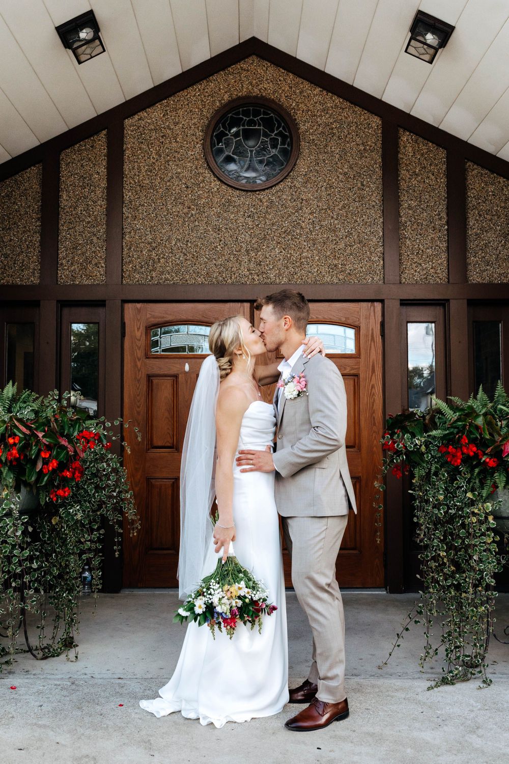 Bride and groom poses with flowers