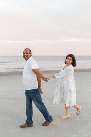 Couple holding hands while walking along a beach path on Amelia Island