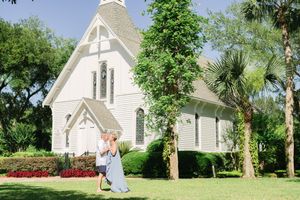 Anniversary portrait of a couple laughing together outdoors in front of a southern chapel in Coastal Georgia and North Florida
