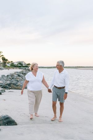 Husband and wife smiling while walking together outdoors