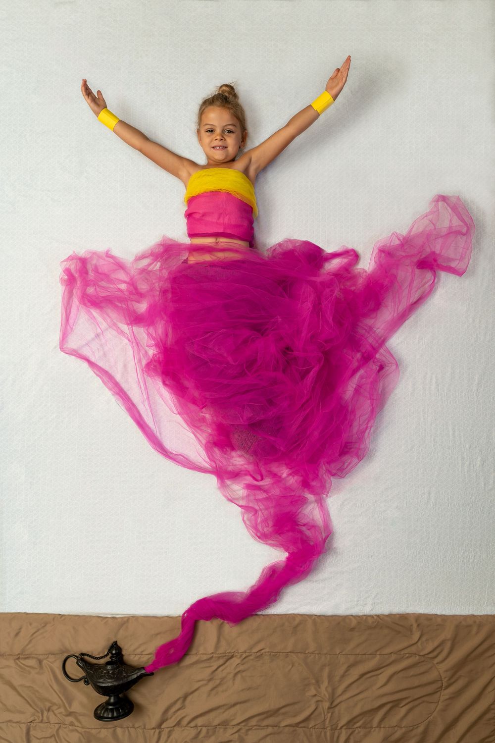 A vibrant dance pose photo series shows a person in yellow and pink flowing across a brown floor in graceful movement.
