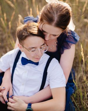 Sweet embraces captured in a sunlit field of tall grass.