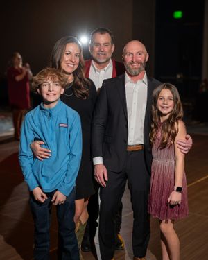 Party guests celebrating and posing for photos at an indoor event with mood lighting.
