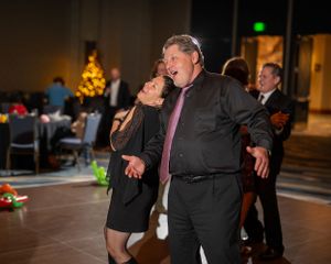 People dancing and socializing at an evening party with mood lighting.