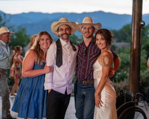 Country-western themed wedding reception with guests in cowboy hats and casual attire.
