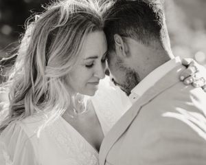 Intimate black and white portrait of newlyweds sharing a tender moment.